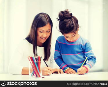 family, children and happy people concept - mother and daughter drawing