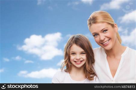 family, children and happy people concept - smiling mother and daughter over blue sky background