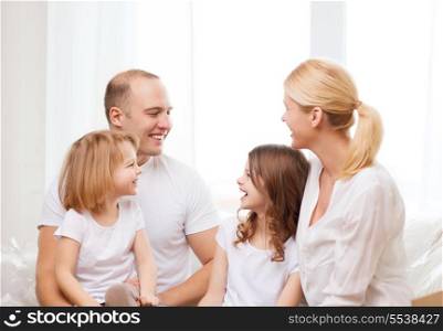 family, children and home concept - smiling family with two little girls at home