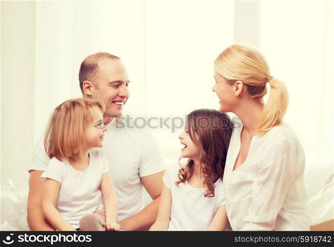 family, children and home concept - smiling family with two little girls at home