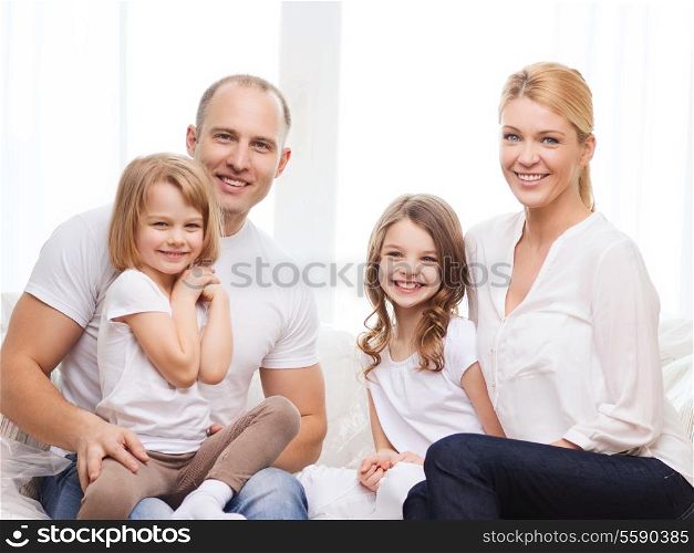 family, children and home concept - smiling parents and two little girls at home