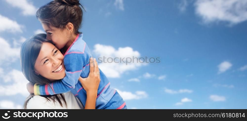 family, children and people concept - happy hugging mother and daughter over blue sky and clouds background