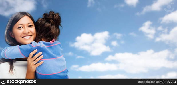 family, children and people concept - happy hugging mother and daughter over blue sky and clouds background