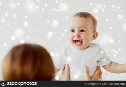 family, children and people concept - happy little baby with mother over snow. happy little baby with mother