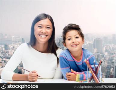 family, children and people concept - happy mother and daughter drawing over city background