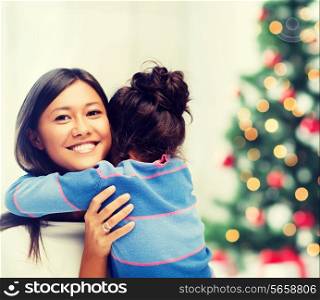 family, children, christmas, x-mas and happy people concept - hugging mother and daughter