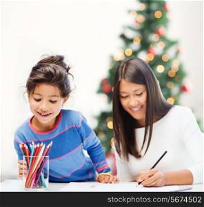 family, children, christmas, x-mas and happy people concept - mother and daughter drawing