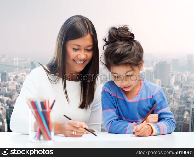 family, children, creativity and happy people concept - happy mother and daughter drawing with pencils over city background