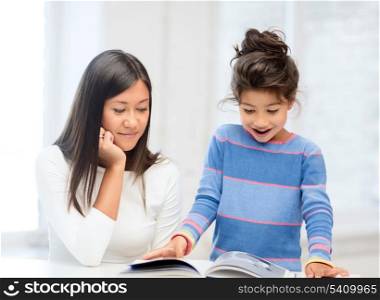 family, children, education, school and happy people concept - mother and daughter with book