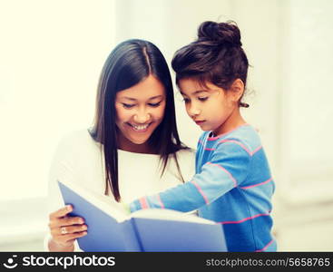 family, children, education, school and happy people concept - mother and daughter with book