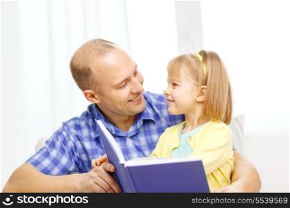 family, children, education, school and happy people concept - smiling father and daughter with book at home