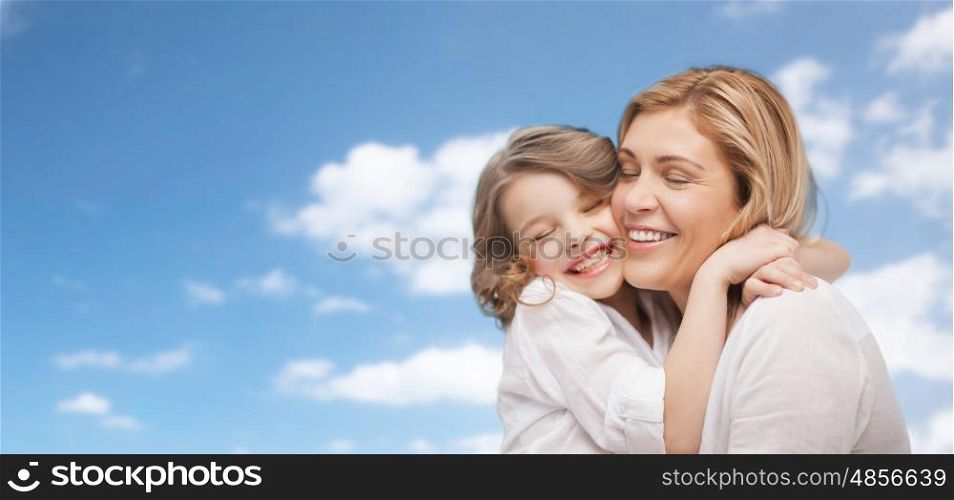 family, children, love and happy people concept - happy mother and daughter hugging over blue sky background