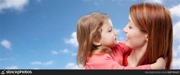 family, children, love and happy people concept - happy mother and daughter hugging over blue sky background