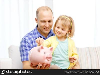 family, children, money, investmen and happy people concept - happy father and daughter with big pink piggy bank