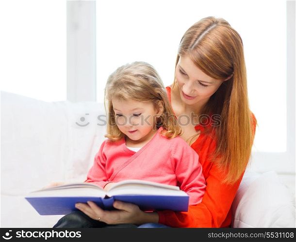 family, children, pre-school and happy people concept - happy mother and daughter with book