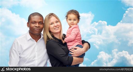 family, children, race and international concept - happy multiracial mother, father and little child over blue sky and clouds background