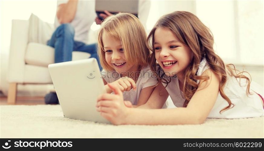 family, children, technology and home concept - smiling sister with tablet pc computer and parents on the back with laptop