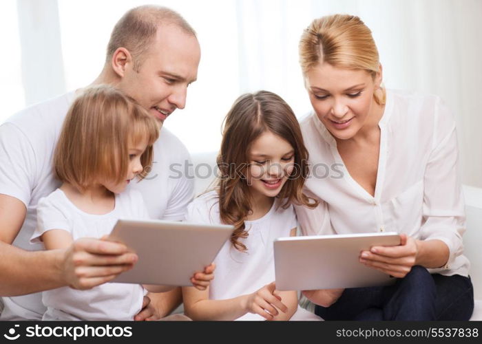 family, children, technology, money and home concept - smiling family and two little girls with tablet pc computers at home