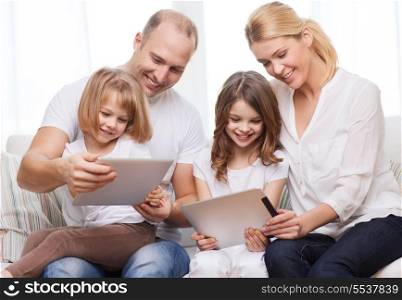 family, children, technology, money and home concept - smiling family and two little girls with tablet pc computers at home