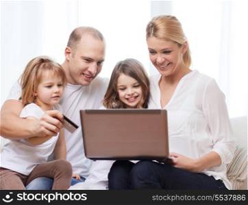 family, children, technology, money and home concept - smiling family and two little girls with laptop and credit card at home