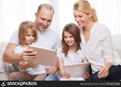 family, children, technology, money and home concept - smiling family and two little girls with tablet pc computers at home