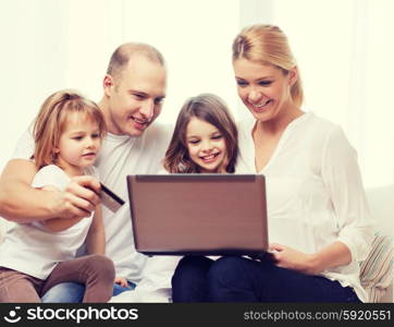family, children, technology, money and home concept - smiling family and two little girls with laptop and credit card at home