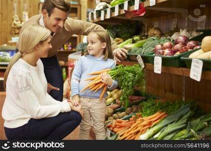 Family Choosing Fresh Vegetables In Farm Shop