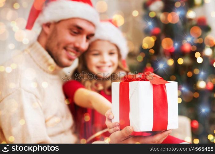 family, christmas, holidays, happiness and people concept - close up of smiling daughter giving father gift box