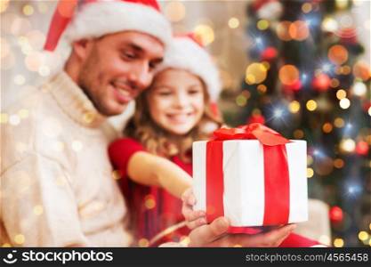 family, christmas, holidays, happiness and people concept - close up of smiling daughter giving father gift box