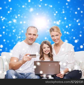 family, christmas holidays, shopping, technology and people concept - happy family with laptop computer and credit card over blue snowy background