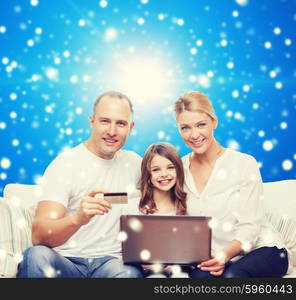 family, christmas holidays, shopping, technology and people concept - happy family with laptop computer and credit card over blue snowy background