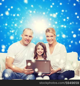 family, christmas, holidays, technology and people concept - smiling family with laptop computer over blue snowy background