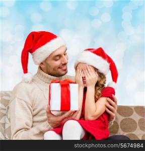 family, christmas, winter holidays and people concept - smiling daughter with closed eyes waiting for present from father over blue lights background