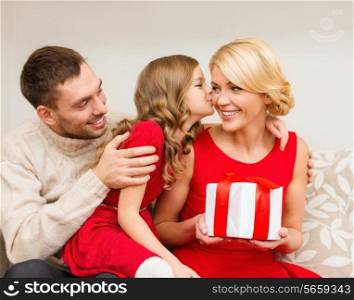 family, christmas, x-mas, happiness and people concept - adorable child kisses her mother and gives present