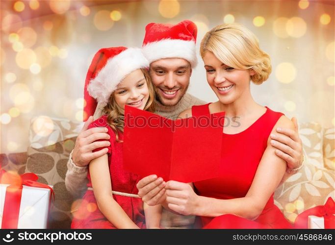 family, christmas, x-mas, happiness and people concept - smiling family in santa helper hats with many gift boxes reading postcard