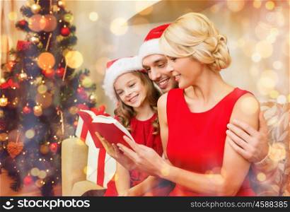 family, christmas, x-mas, happiness and people concept - smiling family in santa helper hats with many gift boxes reading book