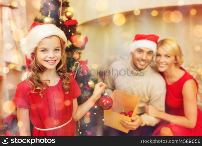 family, christmas, x-mas, happiness and people concept - smiling family in santa helper hats decorating christmas tree