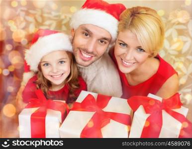 family, christmas, x-mas, happiness and people concept - smiling family in santa helper hats with many gift boxes