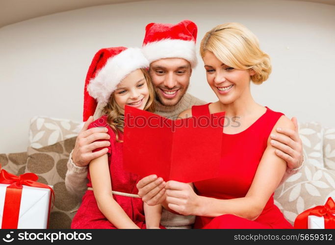 family, christmas, x-mas, happiness and people concept - smiling family in santa helper hats with many gift boxes reading postcard