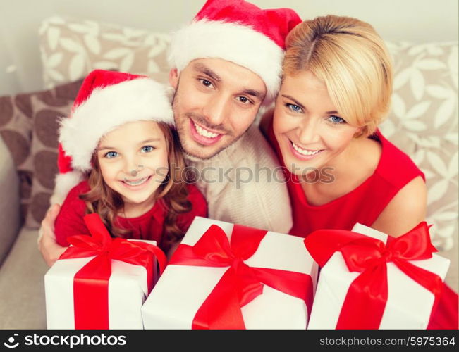 family, christmas, x-mas, happiness and people concept - smiling family in santa helper hats with many gift boxes