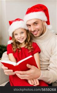 family, christmas, x-mas, happiness and people concept - smiling father and daughter in santa helper hats reading book