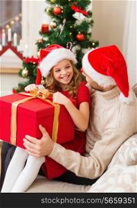 family, christmas, x-mas, happiness and people concept - smiling father and daughter in santa helper hats opening gift box