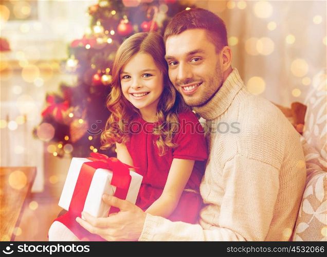 family, christmas, x-mas , happiness and people concept - smiling father and daughter holding gift box