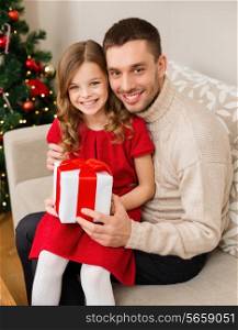 family, christmas, x-mas, happiness and people concept - smiling father and daughter holding gift box