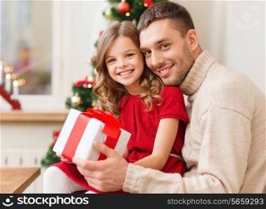 family, christmas, x-mas, happiness and people concept - smiling father and daughter holding gift box