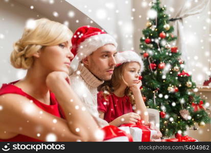 family, christmas, x-mas, winter and people concept - unhappy family at home with many gift boxes