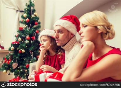 family, christmas, x-mas, winter and people concept - unhappy family at home with many gift boxes