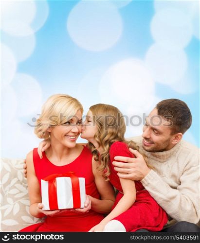 family, christmas, x-mas, winter, happiness and people concept - adorable child kisses her mother and gives present