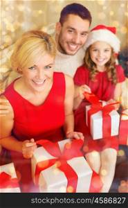 family, christmas, x-mas, winter, happiness and people concept - happy family opening gift boxes