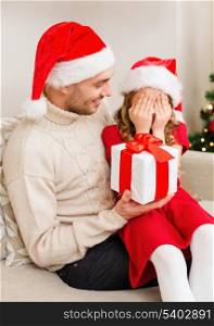 family, christmas, x-mas, winter, happiness and people concept - smiling daughter with closed eyes waiting for a present from fathe